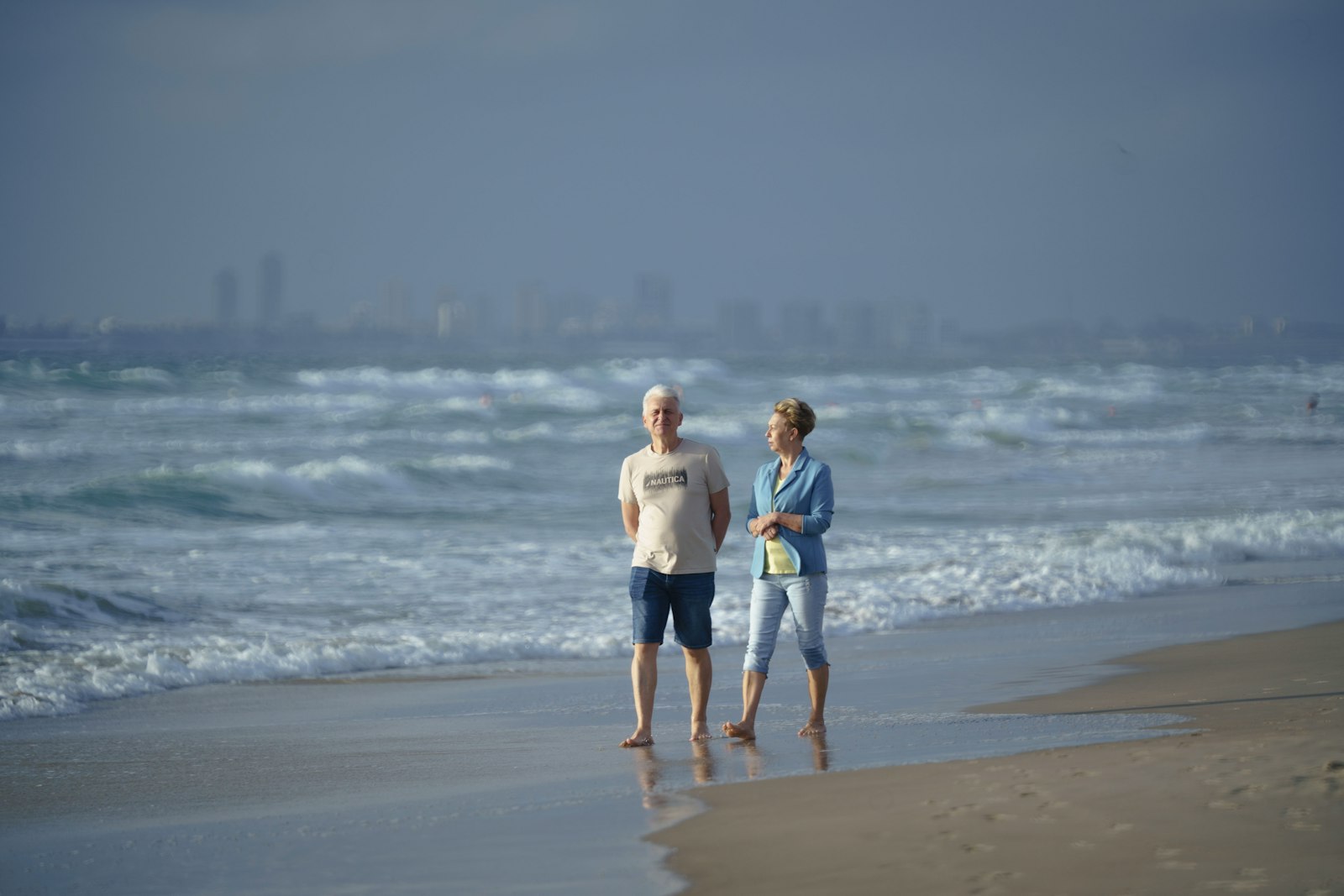Older couple standing together on a San Diego area beach at sunset