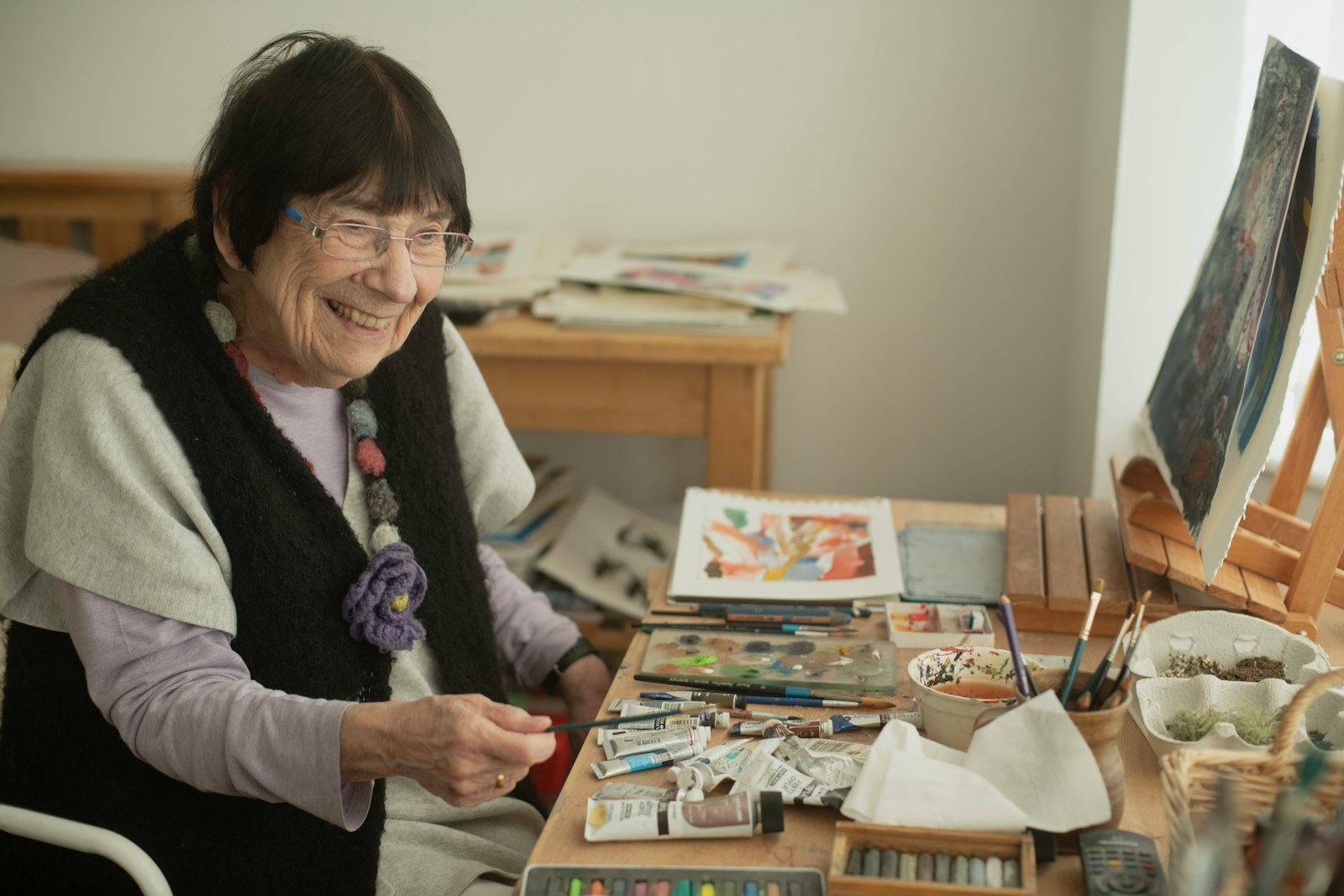 Older woman sitting at a table absorbed in a favorite hobby
